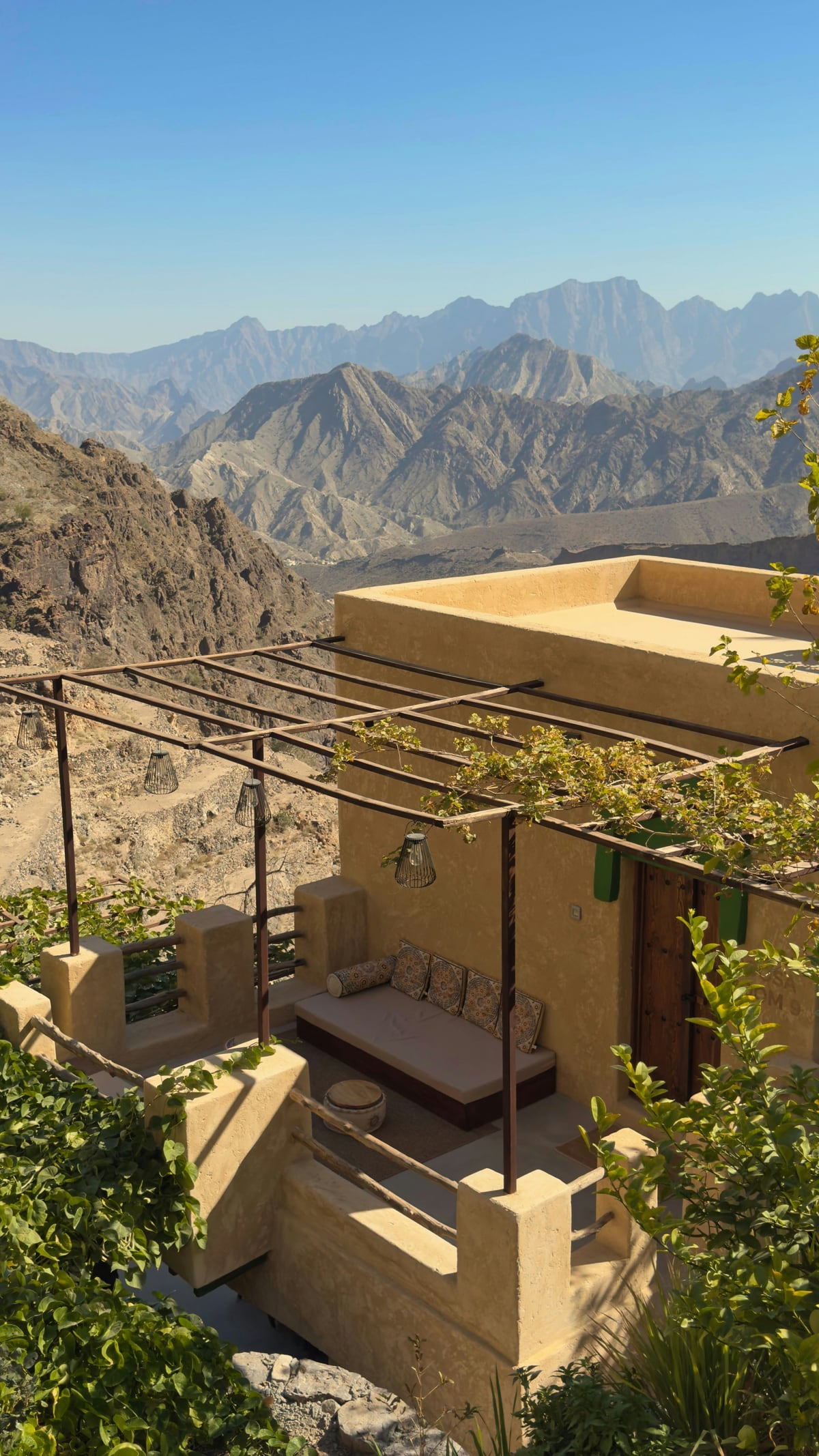 A mountain terrace overlooking rugged peaks in warm daylight